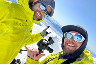 Crew preparing camera gear during a rugged mountain expedition