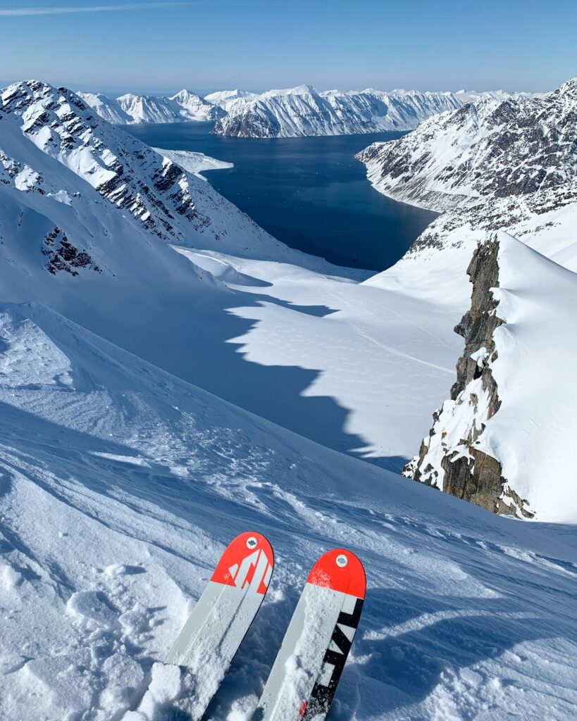 Close-up portrait of a bearded man with frost-covered face in an extreme cold environment.