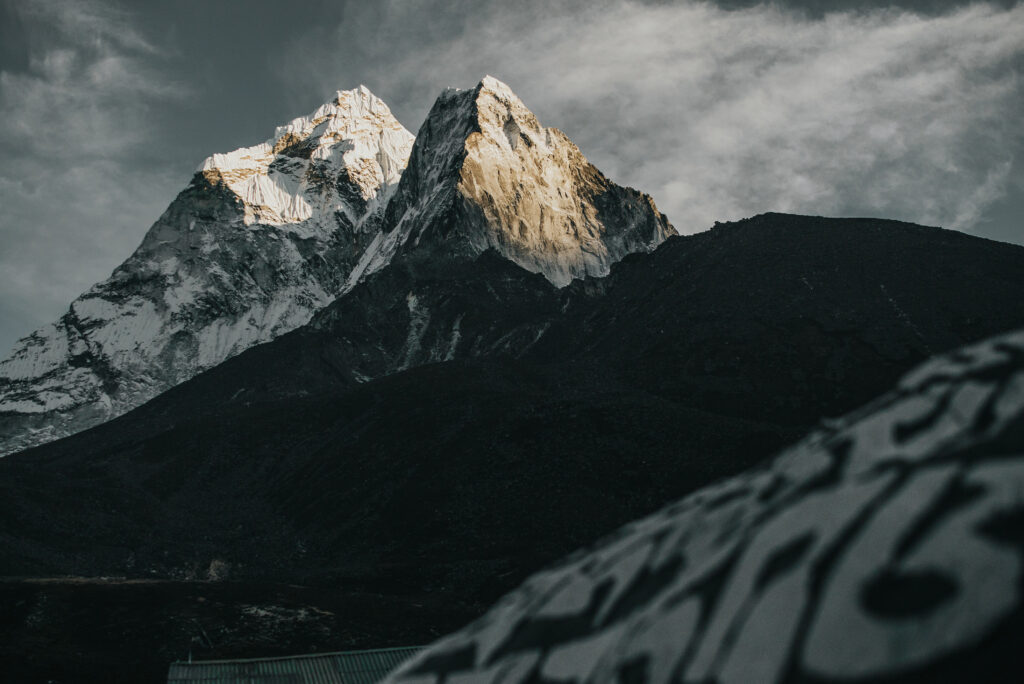 Mountain climber scaling an icy ridge in harsh conditions.