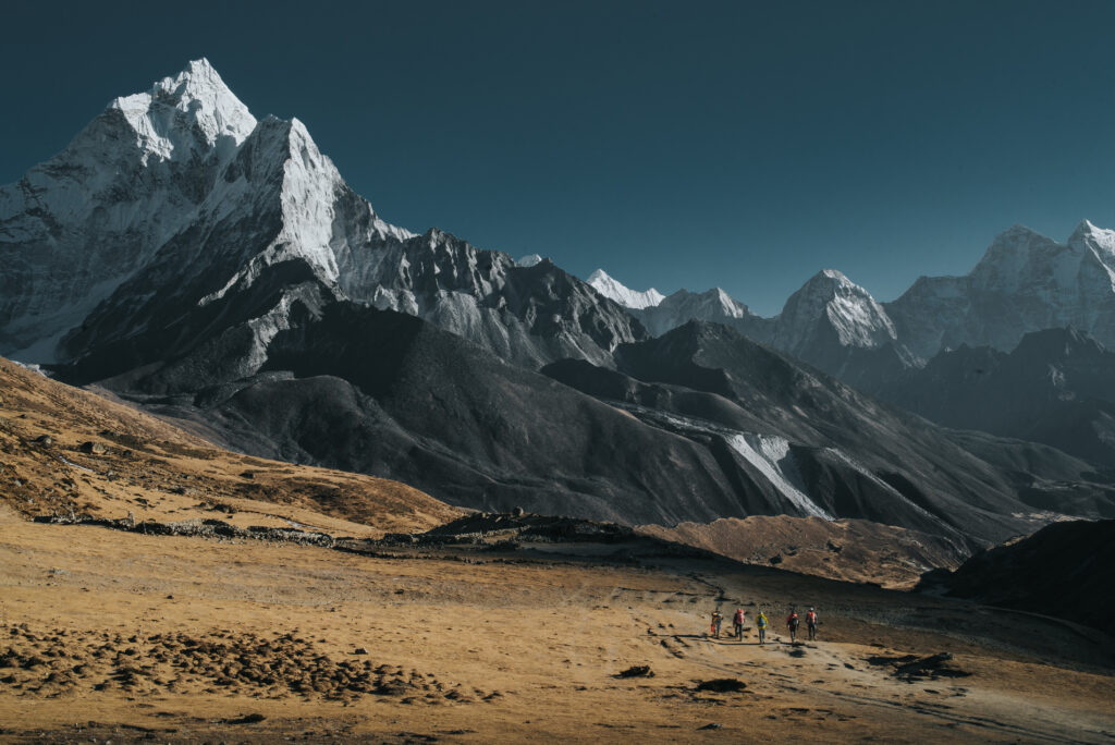 Snowy alpine scene with rugged terrain and blue skies.
