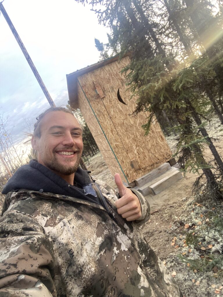 Person in outdoor winter gear, standing in a snowy landscape.