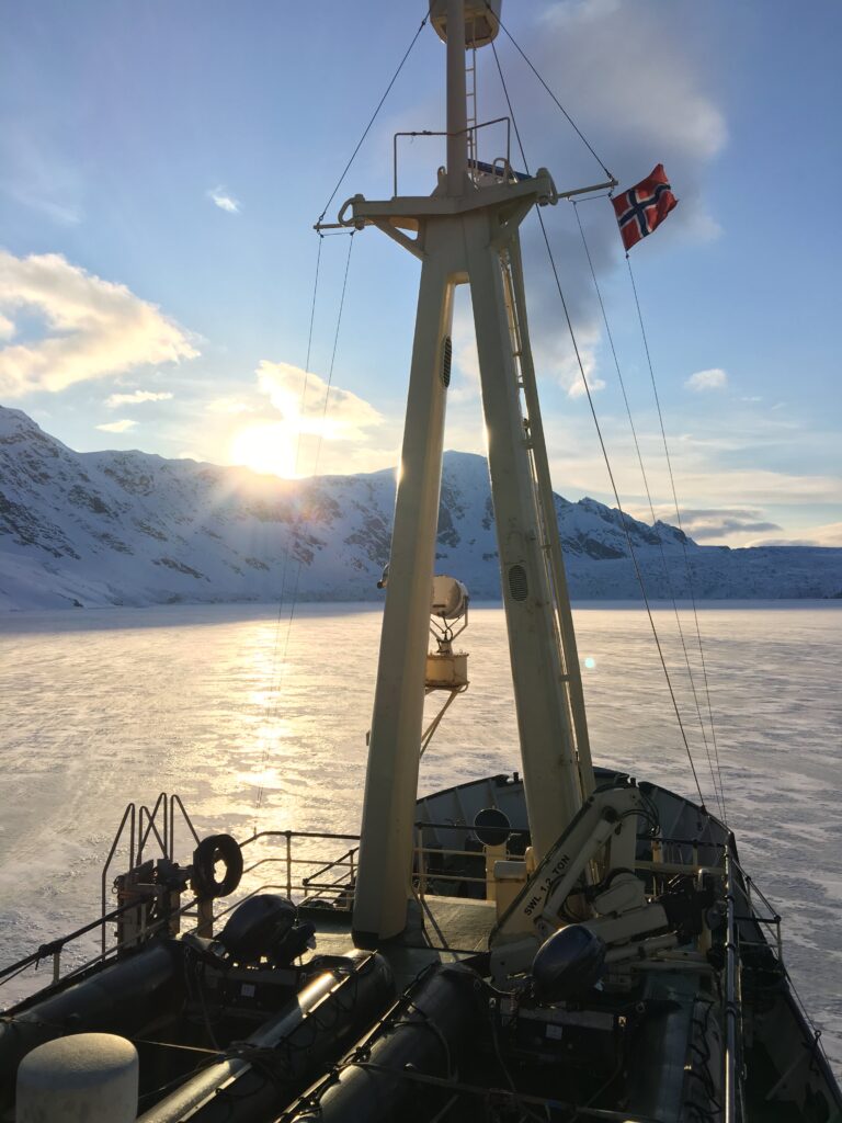 Close-up of a man with frost-covered facial hair, emphasizing cold conditions.