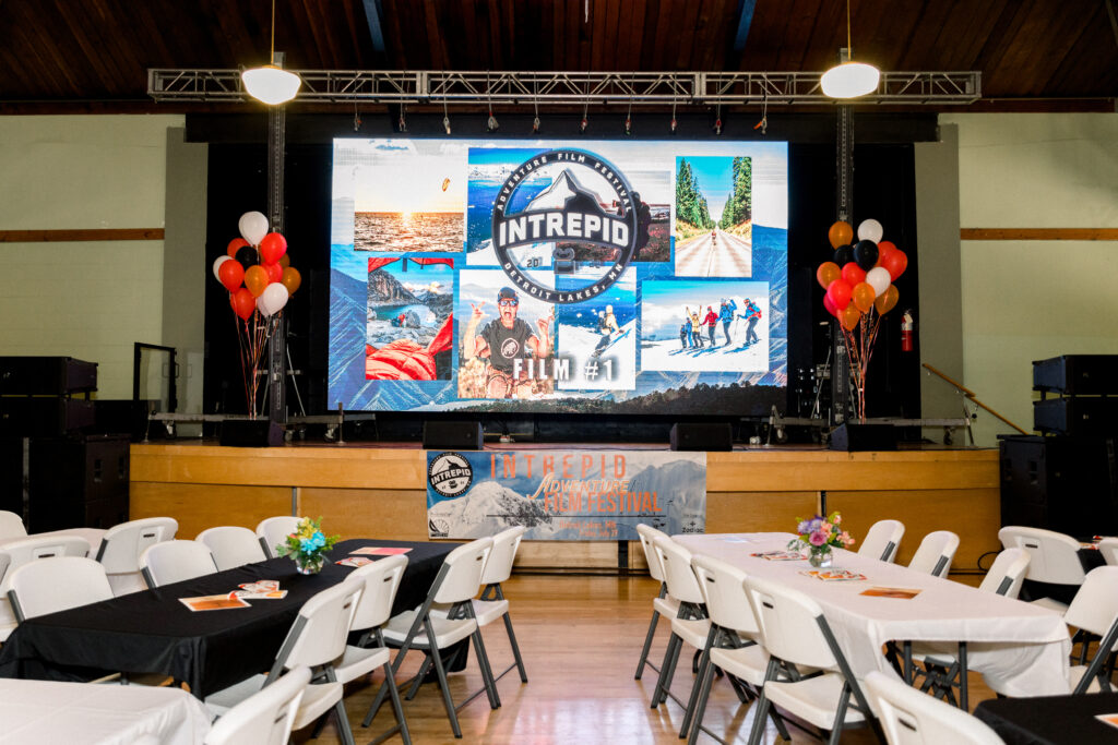 A large party room featuring multiple tables and chairs set up for guests to enjoy.