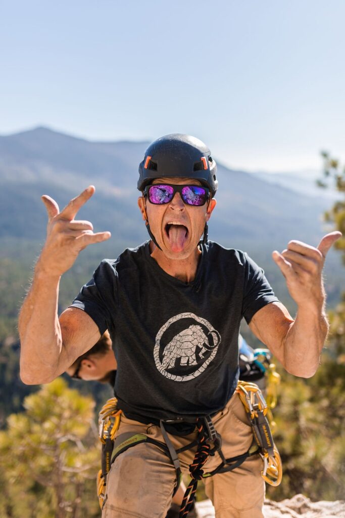 A climber silhouetted against a dramatic mountain backdrop.