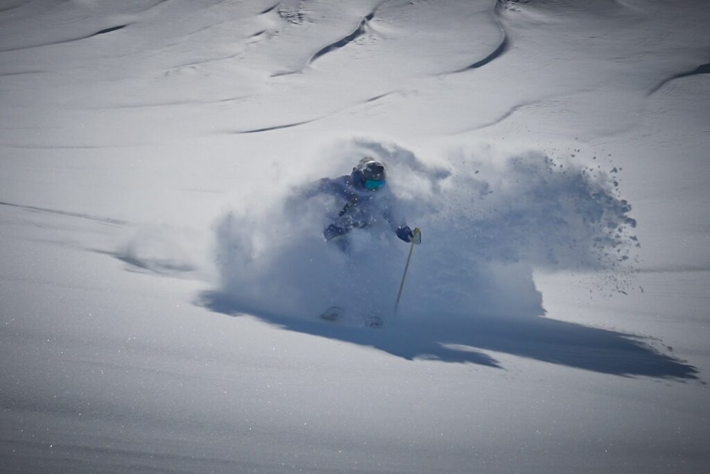 Antarctic explorer standing against a backdrop of ice and snow.